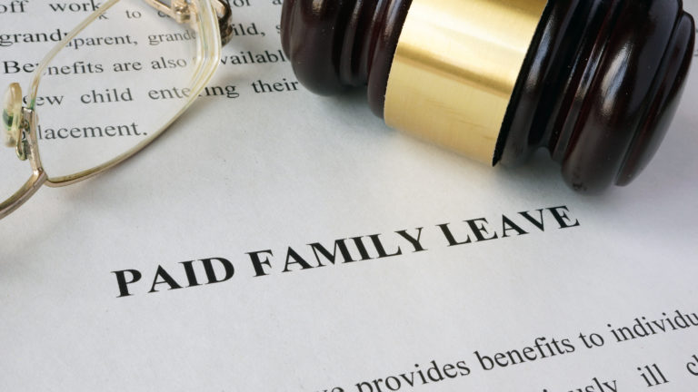 Image of "Paid Family Leave" document with a pair of reading glasses and gavel laying on it.